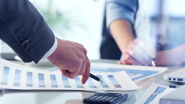 Professional business financial analysis, corporate team reviewing data charts and graphs, executive hand pointing at paper documents in office meeting