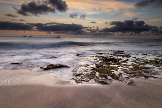 A spectacular sunset over the golden sand and Atlantic ocean seen from the popular Bikini beach at the island of Sal in Cape Verde. It is a nice stretch of beach with a calm cove area that's great for