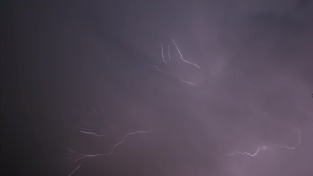 Isolated lightning bolt in the night sky, captured in slow motion.