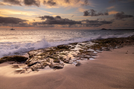 A spectacular sunset over the golden sand and Atlantic ocean seen from the popular Bikini beach at the island of Sal in Cape Verde. It is a nice stretch of beach with a calm cove area that's great for