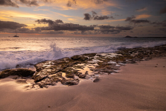A spectacular sunset over the golden sand and Atlantic ocean seen from the popular Bikini beach at the island of Sal in Cape Verde. It is a nice stretch of beach with a calm cove area that's great for