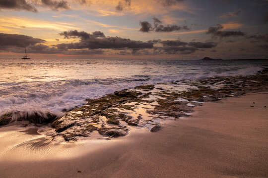 A spectacular sunset over the golden sand and Atlantic ocean seen from the popular Bikini beach at the island of Sal in Cape Verde. It is a nice stretch of beach with a calm cove area that's great for