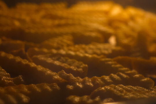 Golden Crinkle-Cut French Fries Baking in Oven - Perfect for Food and Snack Advertisements