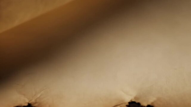 Close up revealing a vintage, aged, and textured parchment paper with visible burns and imperfections