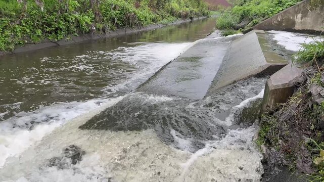 Toxic sewage water pouring from large concrete pipes of a city wastewater treatment facility
