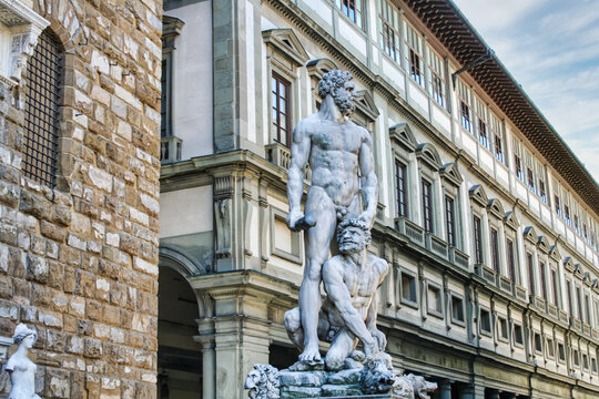 The marble sculpture of Hercules and Cacus by Baccio Bandinelli stands in Piazza della Signoria with the historic building in the background.
