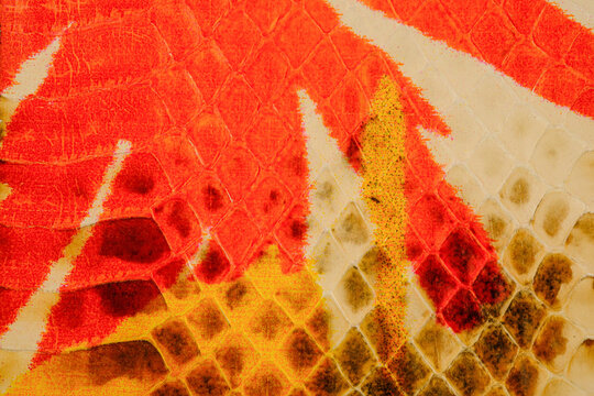 Glossy python leather texture with warm orange reptile scale pattern for exotic fashion background
