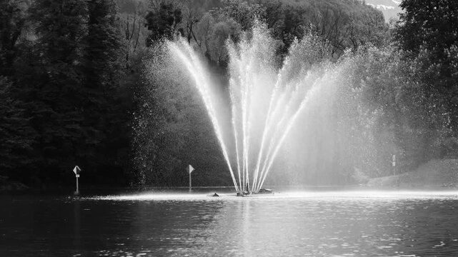 Cinematic fountain spray on lake, ideal for luxury branding, calm backgrounds and elegant storytelling visuals.