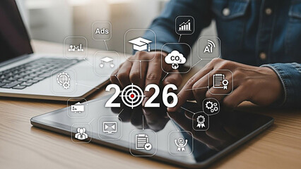 Fototapeta premium Business professional interacts with a tablet showing digital icons representing the future year of 2026