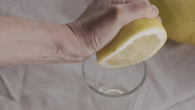 Squeezing a lemon into a glass