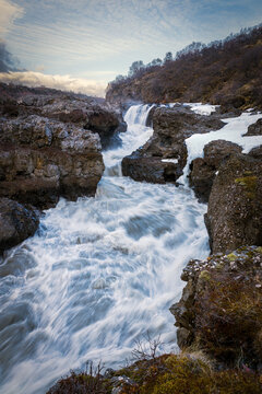 Barnafoss waterfall in Hvita river carving through a volcanic rock canyon in winter in Iceland