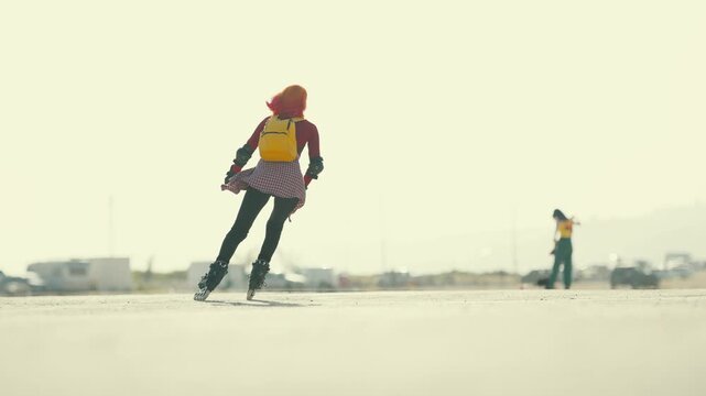 Young woman with pink hair rollerblading on a sunny day