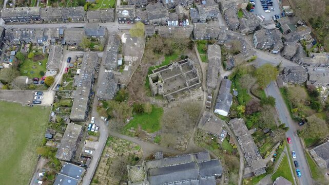 aerial climbing drone shot of the village of heptonstall in west yorkshire with the ruined church and surrounding streets