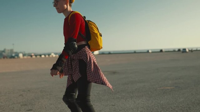Young woman inline skating on asphalt during sunny day