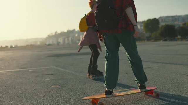 Teenagers longboarding and roller skating together in urban area