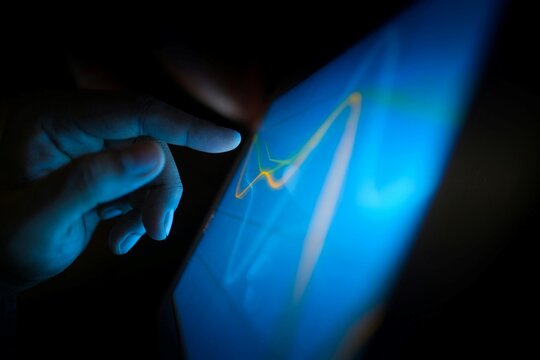 Human hand touching glowing digital tablet screen with abstract data charts represents futuristic technology innovation and interactive business analytics for corporate web.