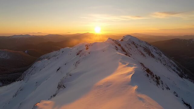 Snowy mountain summit at golden sunset with radiant sunlight streaks peak landscape