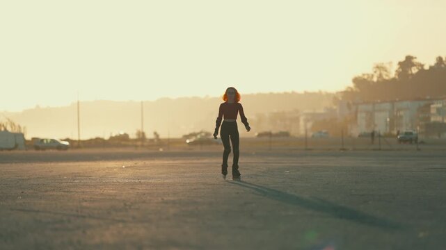 Young woman with red hair roller skating at sunset