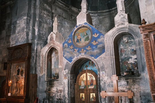 Interior view of the ancient Gergeti Trinity Church in Kazbegi, Georgia. Detail of the medieval stone altar, religious frescoes, and orthodox icons inside the 14th-century mountain monastery 