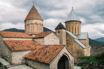 Fototapeta premium Detailed view of the medieval stone towers and tiled roofs of the Ananuri Fortress complex in Georgia. Historic 17th-century orthodox architecture overlooking the Aragvi River valley