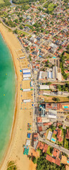 Fototapeta premium Aerial drone panorama of Meaipe Beach during the Brazilian university games in Guarapari, Espírito Santo, Brazil. Tropical coastline with event structures, ocean and summer scenery.