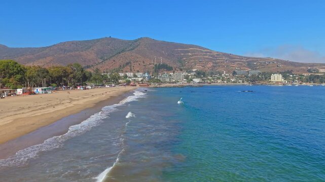 Flying over the large beach at Papudo, Chile, a secluded natural spot on a sunny day, an exclusive town on the central coast