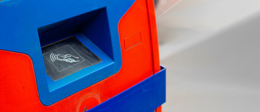 Horizontal street photo banner. Blue red ATM machine with contactless reader panel, plastic card icon. Concept of salary, credit, loan, debt, pay tax, cash money, buy, debit, wages, budget. Copy space
