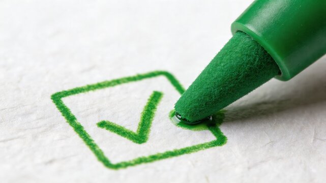 A close-up of a green marker pen drawing a checkmark in a checkbox on a white paper, symbolizing assessment and risk management in a thorough and meticulous process.
