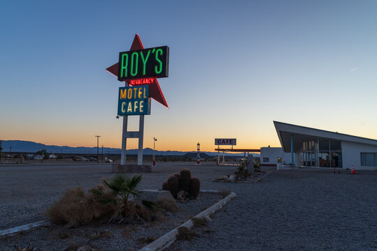 Amboy, USA - April 6th 2026: Iconic neon sign of Roy's Motel and Caf&eacute; glowing at dusk along historic Route 66 in the town of Amboy, California, featuring classic mid-century Googie architecture