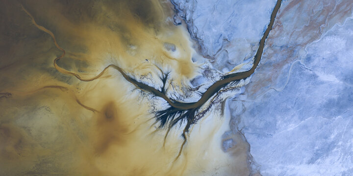 Aerial view of the abstract mineral patterns and salt crusts of Searles Lake with branching dark channels San Bernardino County, California, United States.