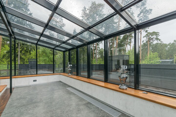 Obraz premium Glazed terrace in a luxurious mansion overlooking a beautiful natural landscape. Stylish lamps on a wooden windowsill.