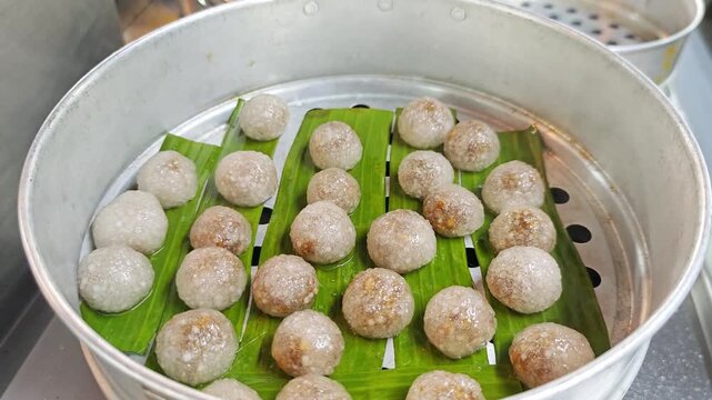 Freshly steamed Thai tapioca dumplings named Sakoo Sai Moo in a steamer.