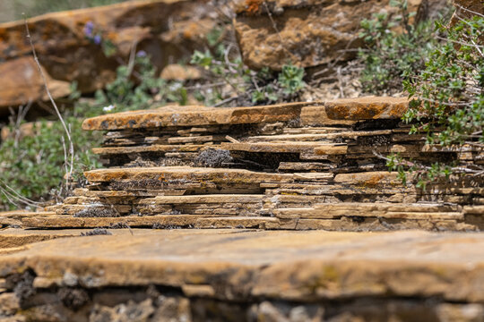 Structure of mountain formations consisting of many flat stone plates. Types of stone structures. Different types of rocks. Petrology or petrography. Study of mountain formations
