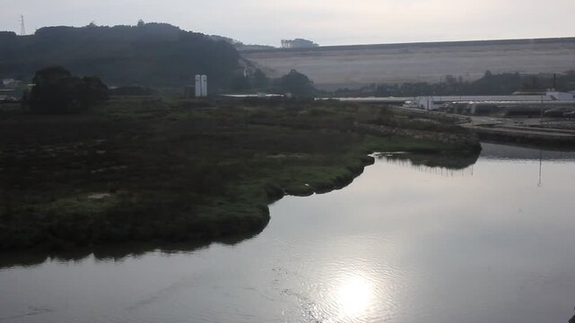 Industrial mud dam reservoir and seagulls over a river in San Cibrao, Spain
