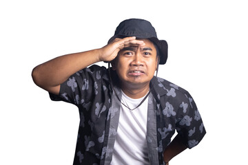Naklejka premium Young man wearing a black bucket hat and patterned shirt shielding his eyes while looking at the camera with a disgusted and confused expression. white background.