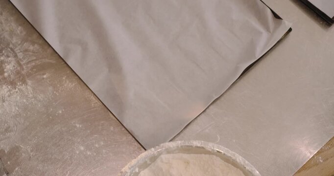 Adult African American baker after placing dough rounds brushing egg wash for proofing at bakery