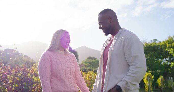African American couple exchanging smiles in sunlit vineyard with lens flare, leaning and hugging