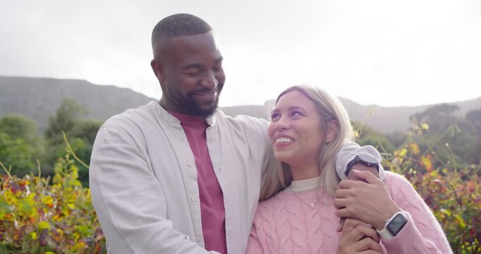 African American couple sharing affection as man draping arm on shoulder, smartwatch in vineyard