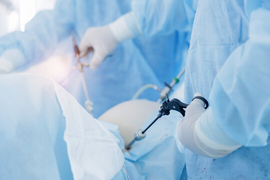 Surgeons manipulating trocars during minimally invasive surgery in medical clinic