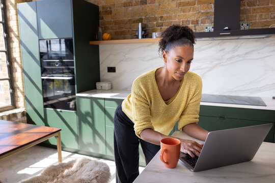 Woman Working from home on Laptop with in Modern Kitchen