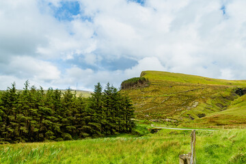 Obraz premium Gleniff Horseshoe in County Sligo, Ireland, with rolling grassland beneath steep limestone mountains and bright clouds. A scenic drive through one of Irelands classic valleys.