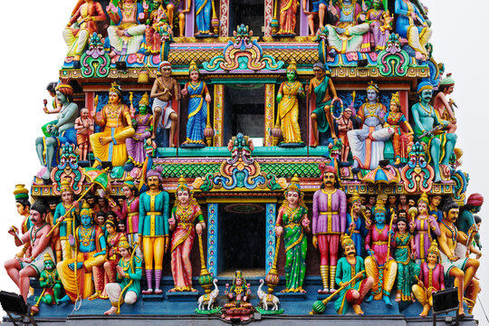Fragment gopuram of Sri Mariamman Temple entrance roof decorated with colorful statues of hindu gods on white background. The oldest Hindu temple in Singapore, is located in the historic Chinatown