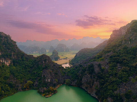 Scenic landscape of Ninh Binh at sunset with limestone mountains and tranquil river