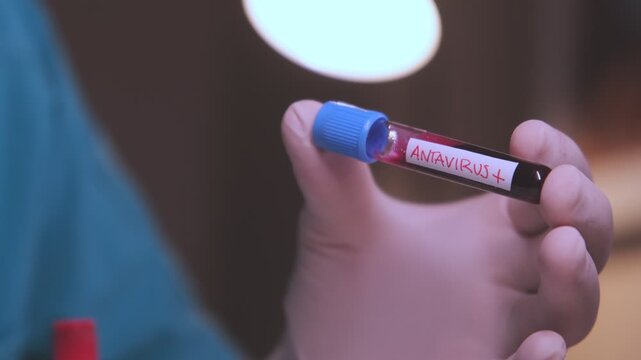 Close-up of a laboratory technician examining a blood sample tube testing positive for antavirus