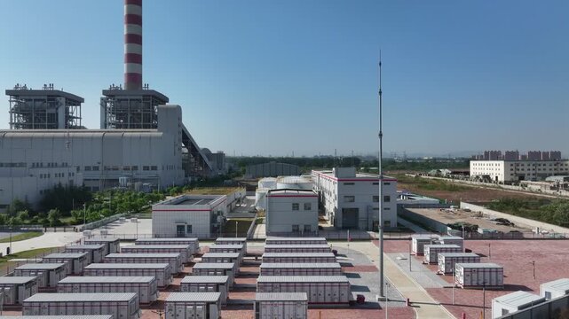 Thermal power plant with rows of energy storage container units under clear blue sky