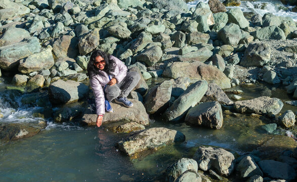 Portrait shot of an independent Indian woman enjoying in the beautiful lidder river, at Chandanwari, Pahalgam, Kashmir, India.