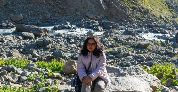 Portrait shot of an independent Indian woman enjoying in the beautiful lidder river, at Chandanwari, Pahalgam, Kashmir, India.