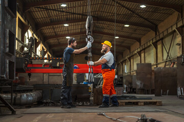 Fototapeta premium Industrial workers preparing heavy crane hook for lifting