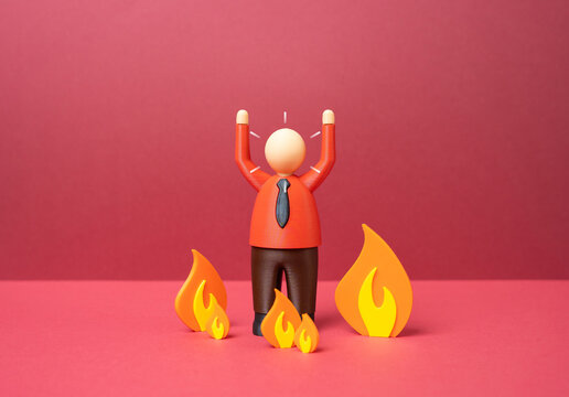 An office worker panics in the middle of a fire. Stress and burnout at work. Workplace anxiety, emotional exhaustion and pressure caused by corporate overload and deadlines.