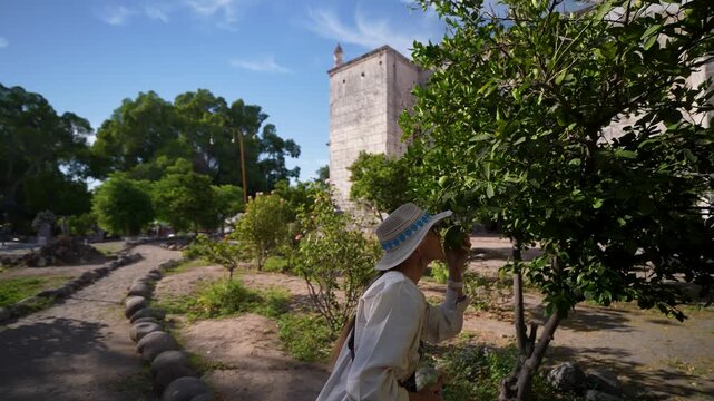 Mature woman enjoys sightseeing at the Mission Church in San Ignacio Baja California Mexico while capturing moments with her camera.